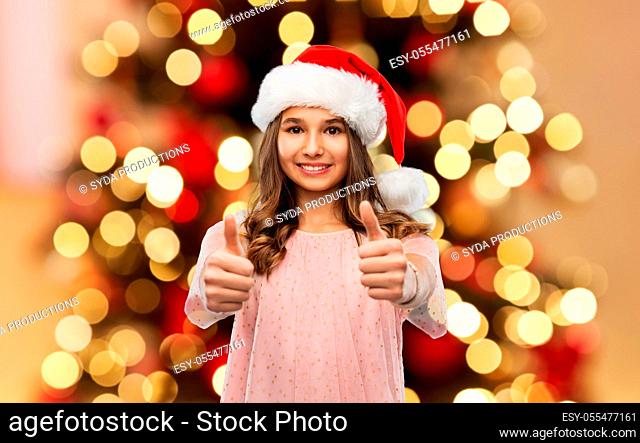 happy teenage girl showing thumbs up on christmas