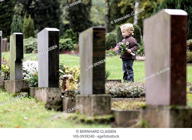 GERMANY, WRIEDEL, Boy, 3 years, with flowers at a grave - WriedelGermany, 16/10/2013