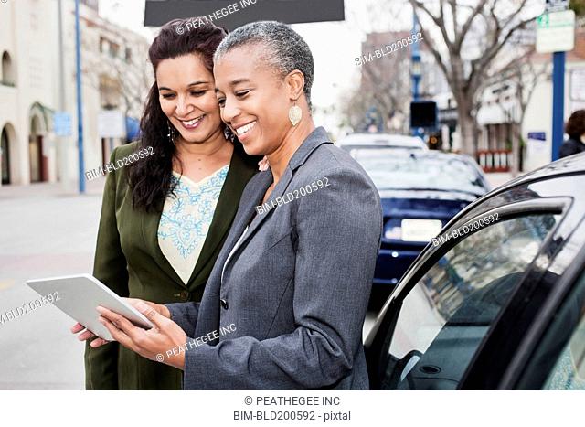 Businesswomen looking at digital tablet outdoors