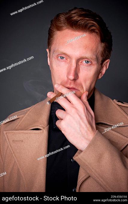 elegant man wearing a beige coat with a cigar in his mouth