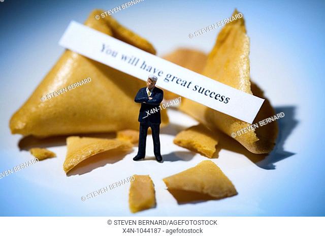 Miniature businessman in front of fortune cookies with message reading you will have great success