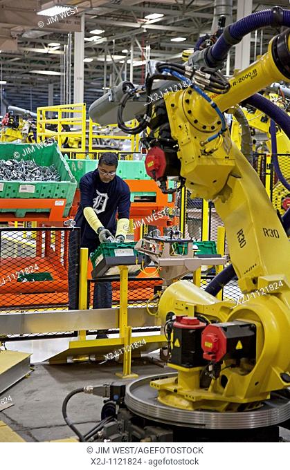 Detroit, Michigan - A worker and a robot on the assembly line for Chrysler's new Jeep Grand Cherokee at the Jefferson North Assembly Plant