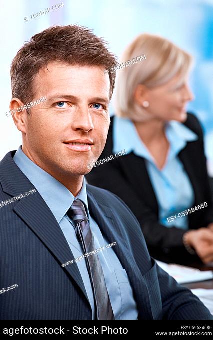Portrait of smiling businessman looking at camera office