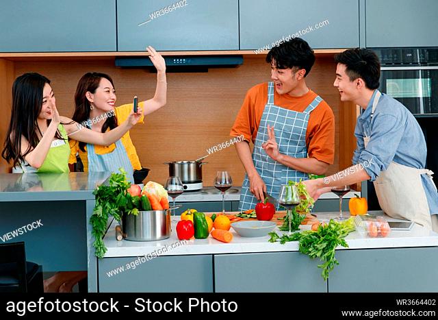 Happy young people cook in the kitchen
