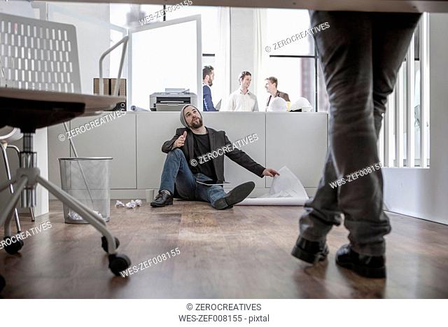 Creative professional sitting on office floor