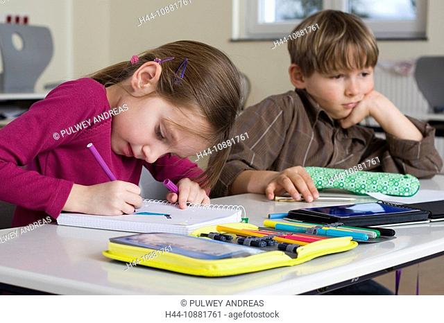 sechsjähriges Mädchen schreibt angestrengt im Klassensaal, mr