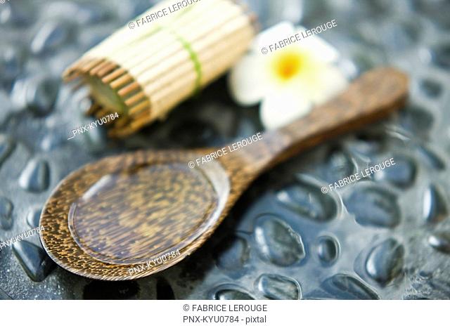 Close-up of a bar of soap with a flower and aromatherapy oil in a spoon