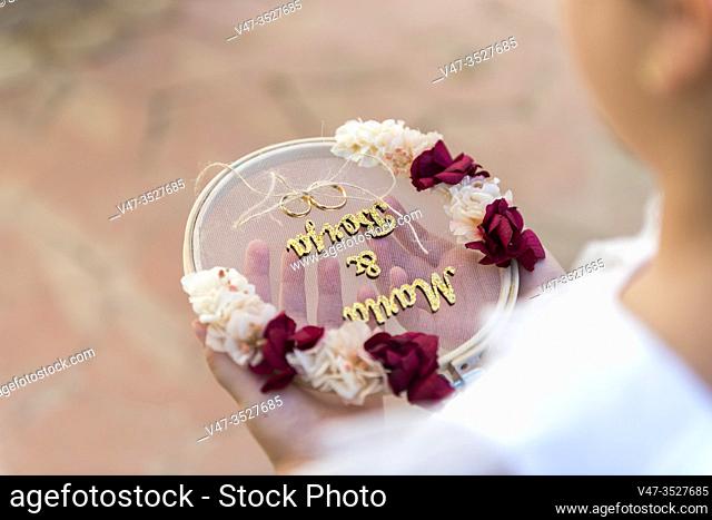 A girl wears the rings to the bride and groom at the wedding ceremony