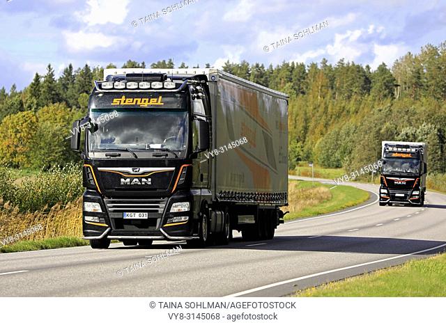 Two MAN semi trailer trucks of Stengel LT haul goods along highway on a beautiful day of early autumn. Salo, Finland - September 14, 2018