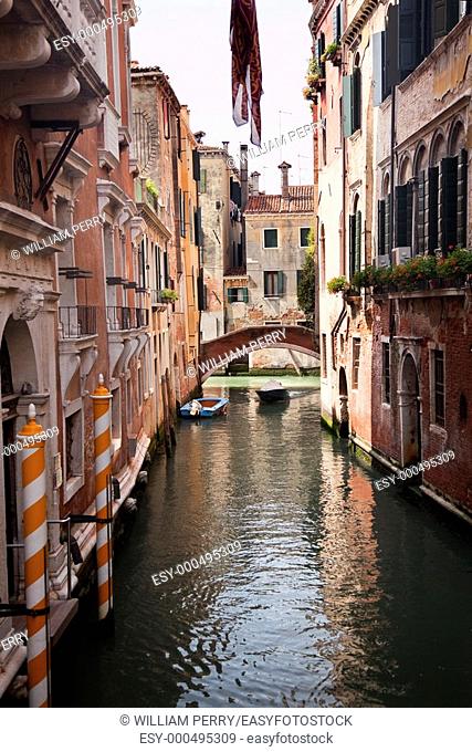 Small Canal Bridge Yellow Poles Buildings Boats Reflections Venice Italy