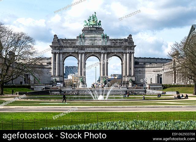 Brussels European Quarter, Belgium - March 15, 2023 - The Triumphal arch at the Cinquentenaire park with green lawns and a fountain
