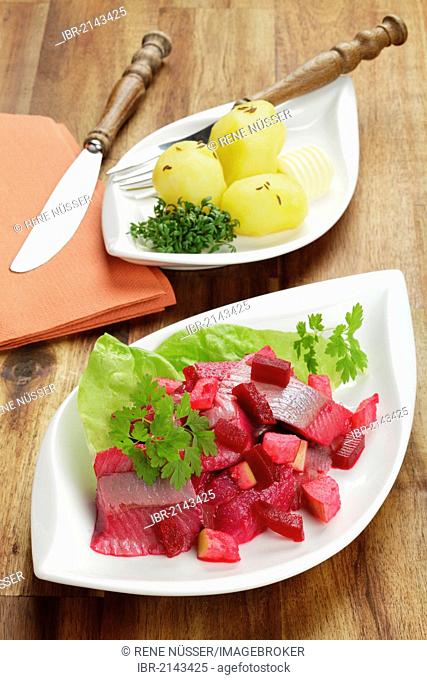 Salad of soused herring with beetroot and apple pieces, served with boiled potatoes