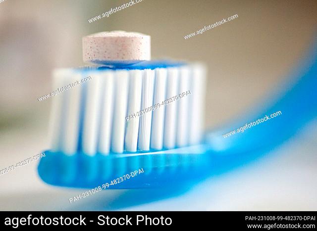 ILLUSTRATION - 29 September 2023, Berlin: A so-called toothbrush tablet lies on a toothbrush in the bathroom. Toothpaste is put on the brush