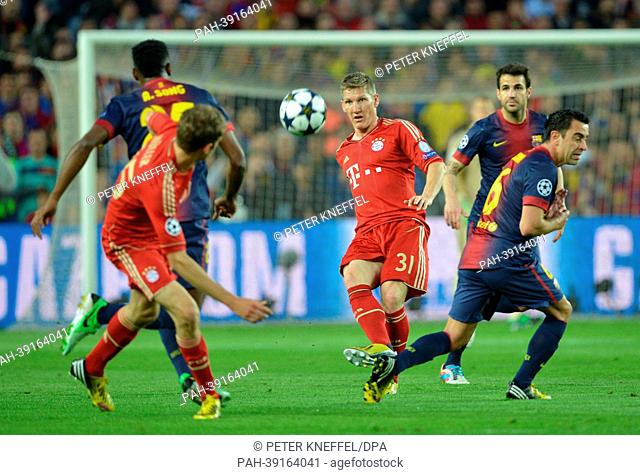 Barcelona's Xavi Hernandez (R) and Munich's Bastian Schweinsteiger (C) vie for the ball during the UEFA Champions League semi final second leg soccer match...