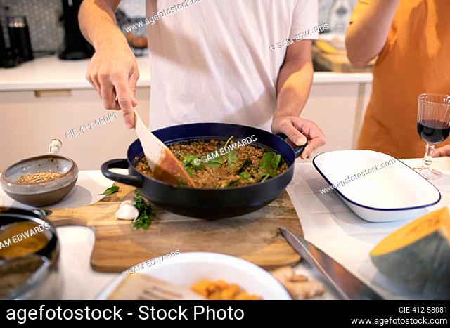 Young man cooking dinner in kitchen