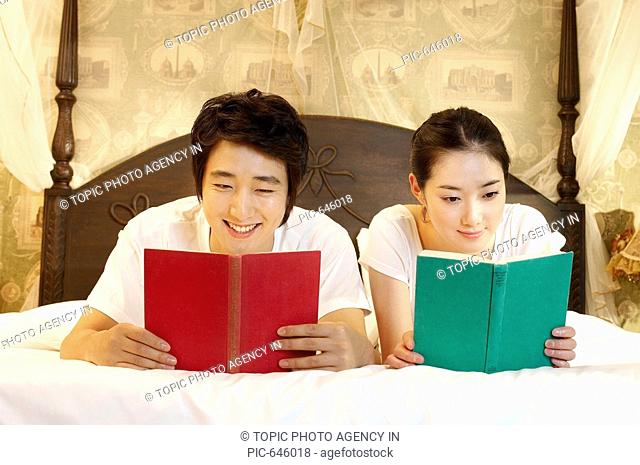 Young Couple Reading on the Bed, Korea