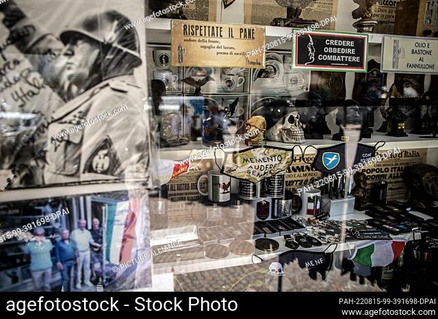11 August 2022, Italy, Predappio: Devotional objects of the former Italian dictator Benito Mussolini and fan articles of fascism are sold in a store in...
