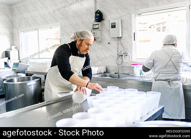 Mature chef couple working in dairy factory