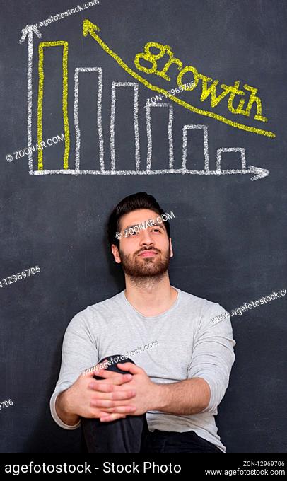Man with drawn graph showing the growth of his stock