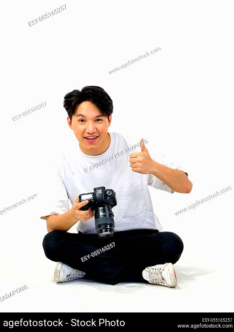Asian photographers look at the pictures taken on the camera screen while sitting in a white photography scene. The atmosphere in the photo studio