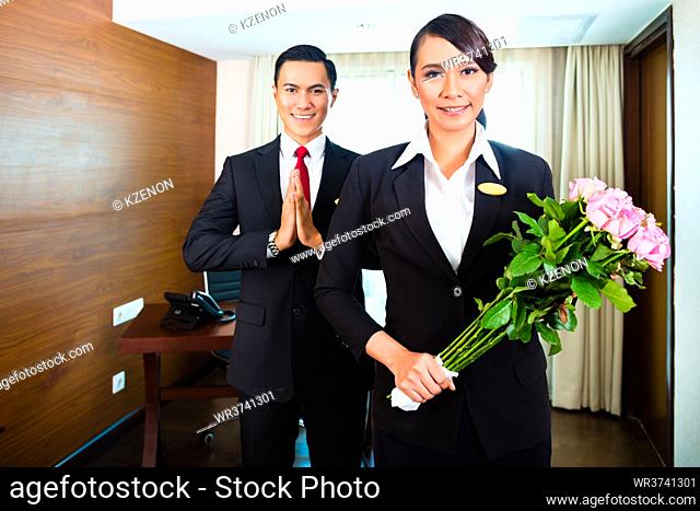 Portrait of hotel staff greeting with flowers