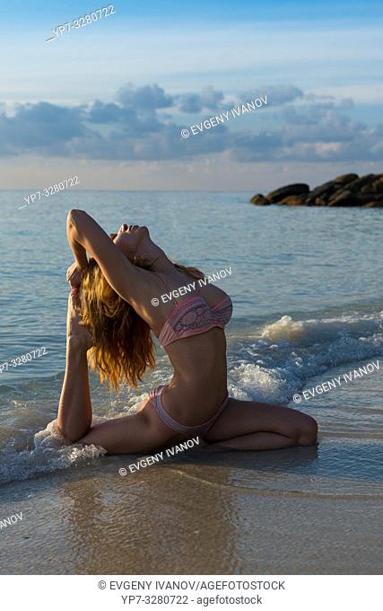 Pigeon pose - beach yoga in Thailand, Koh Lipe island