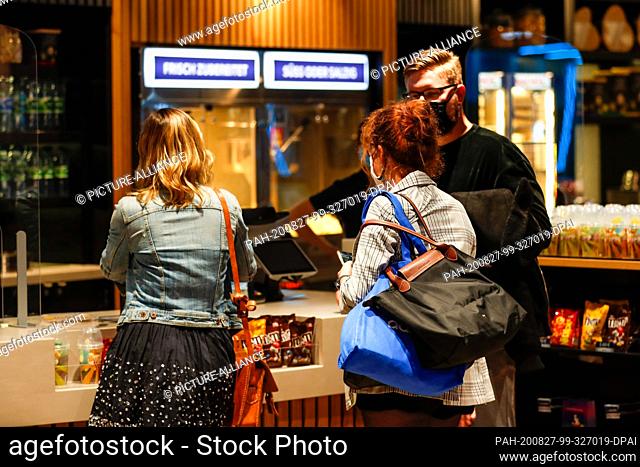 26 August 2020, Berlin: Moviegoers wearing masks stand at the box office in the UCI Luxe Mercedes seat. Photo: Gerald Matzka/dpa-Zentralbild/ZB