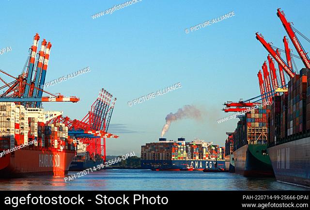 14 July 2022, Hamburg: The container ship CMA CMG Zheng He of the shipping company CMA CMG docks at the container terminal Eurogate (l) in Waltershofer Hafen