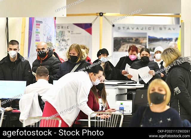 People fill out questionnaires in a vaccination center at former shopping centre Prior in Pilsen, Czech Republic, on November 29, 2021