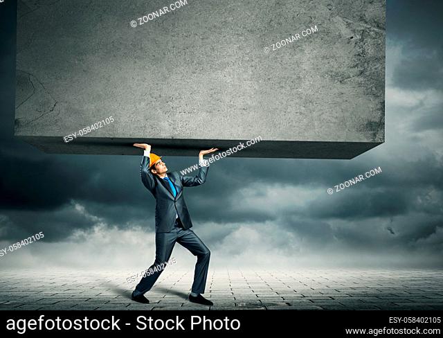 Engineer man in suit and helmet lifting wall above head