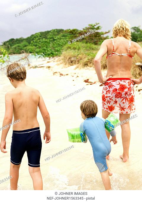 Mother with two sons walking on beach