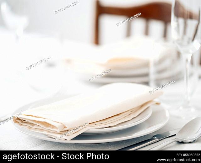Beautiful table setting in white colors. Empty white plates. Set table for romantic dinner for two at home