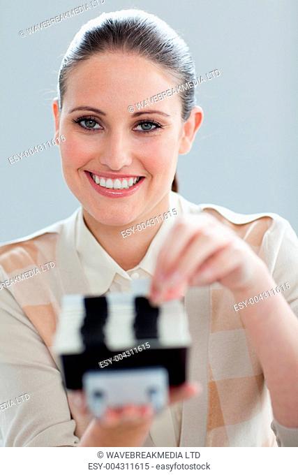 Self-assured businesswoman consulting a business card holder