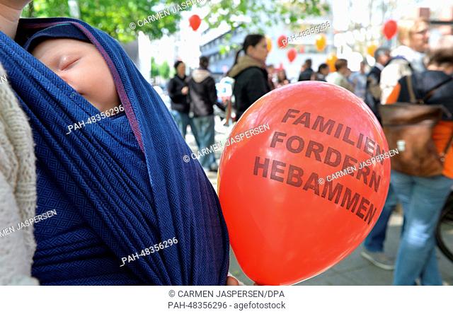 Eleven-week-old Ena sleeps as her mother holds a balloon which reads 'Families demand midwifes' at a demonstration for better pay for midwifes on the occasion...