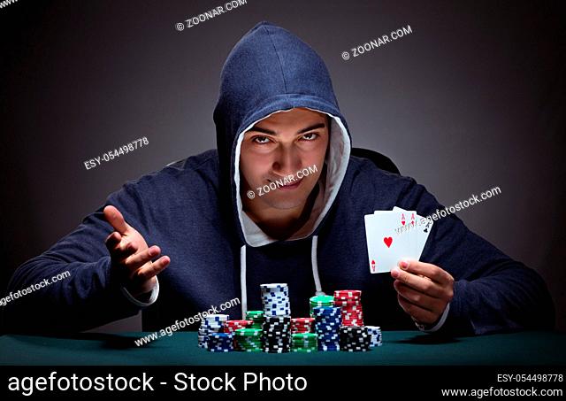 The young man wearing a hoodie with cards and chips gambling