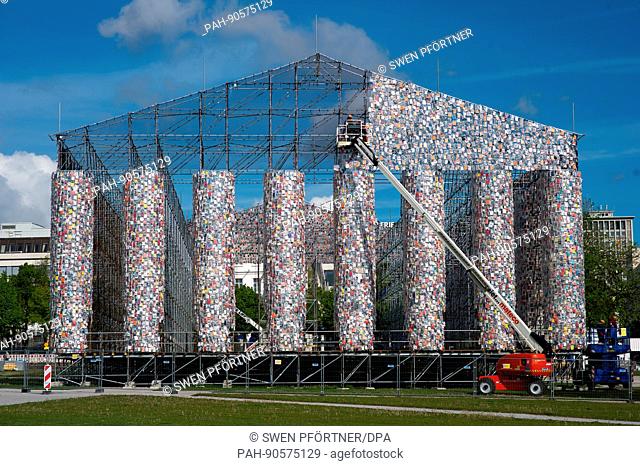 dpatop - Workers attach books covered in plastic on the steel frame of the documenta artwork 'The Parthenon of Books' in Kassel,  Germany, 09 May 2017