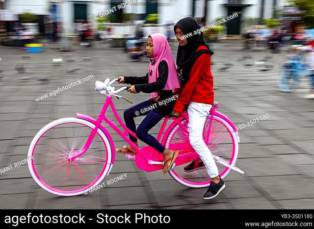 Indonesian Children Cycling In Taman Fatahillah Square, Jakarta, Indonesia