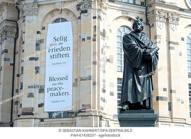 A banner with a quote from the Sermon on the Mount, ""Selig sind, die Frieden stiften"" (lt.""Blessed are the peacemakers"") in German and English on the facade...