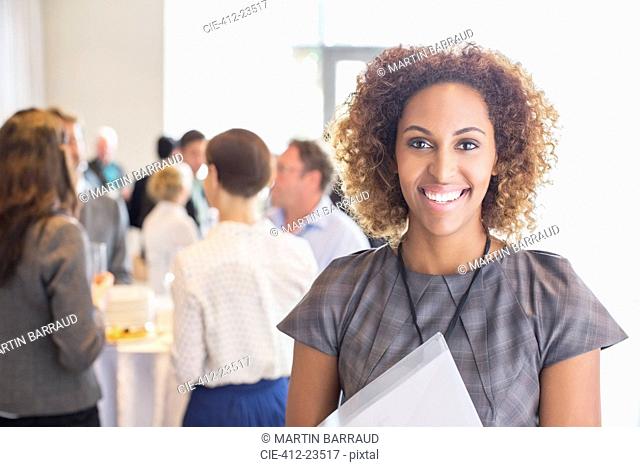 Portrait of young businesswoman standing and smiling in office hall