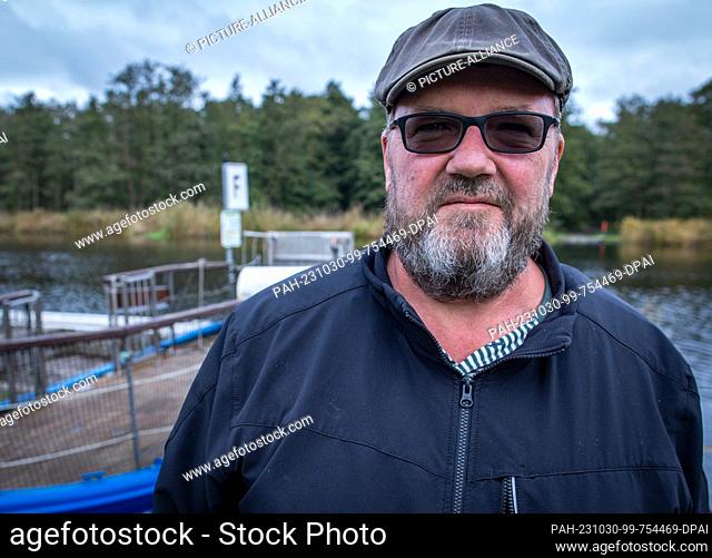 PRODUCTION - 26 October 2023, Mecklenburg-Western Pomerania, Stolpe: Ferryman Ulf Radicke stands at the pier of the small passenger ferry across the Peene and...