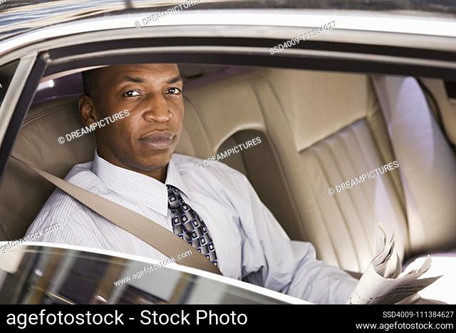 African businessman riding in back seat of car