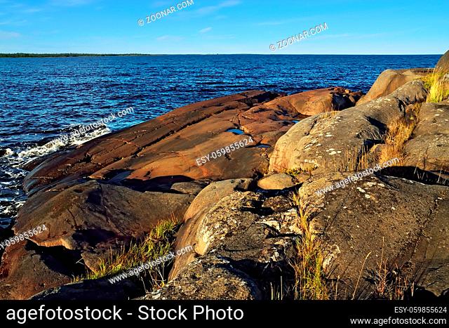 Beautiful red cliffs on the shore of the White sea. North Karelia, Russia