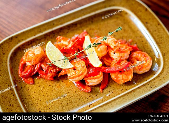 platter of vegetables and seafood. Assorted seafood: fried calamari, grilled shrimp with sauce. Baked fish fillet. Spices and lemon for seafood