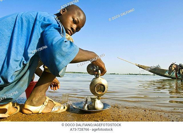 Young man preparing tea by Niger River, Segou, Mali