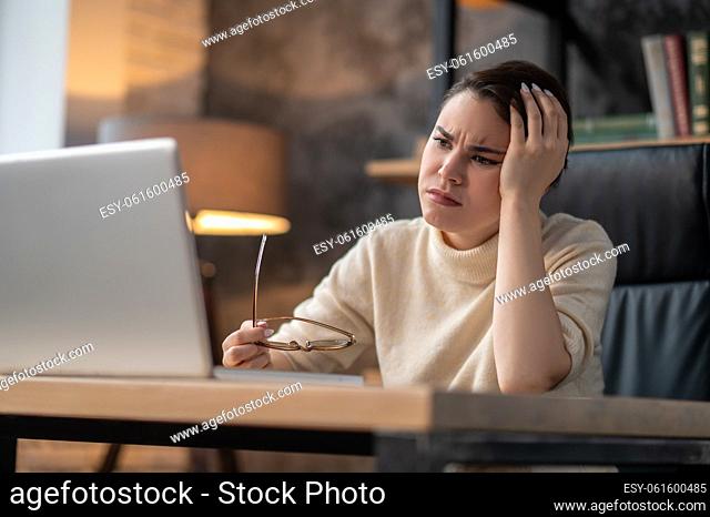 Tired woman. A woman in beige sweater looking tired and upset