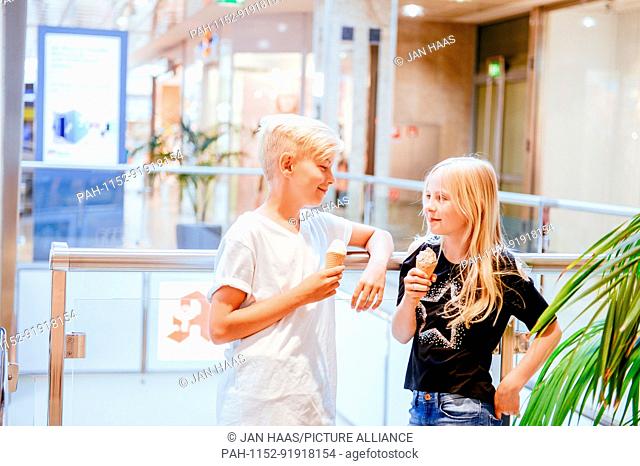 A boy and a girl eating icecream in a shopping mall, taken on 16/06/17 in Frankfurt (model released) | usage worldwide. - Frankfurt am Main/Hessen/Germany
