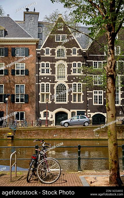 AMSTERDAM, NETHERLANDS - SEPTEMBER 21, 2017: Amsterdam canal with typical dutch houses and houseboats during morning in Holland, Netherlands