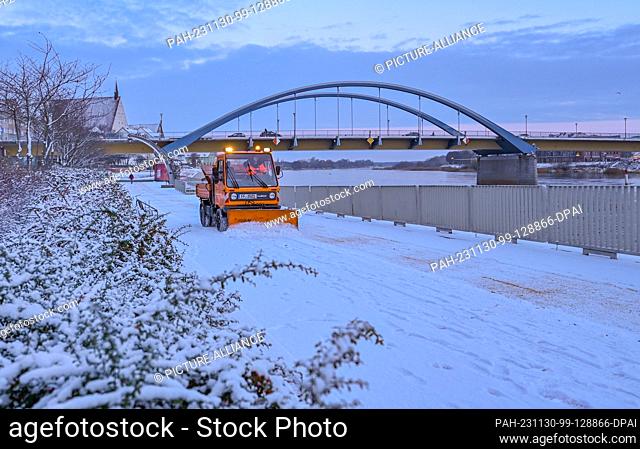30 November 2023, Brandenburg, Frankfurt (Oder): The city of Frankfurt (Oder)'s winter road clearance service is out and about on the promenade along the...