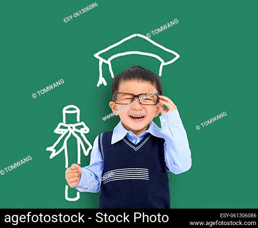 Happy child in graduation cap and holding the diploma against chalkboard