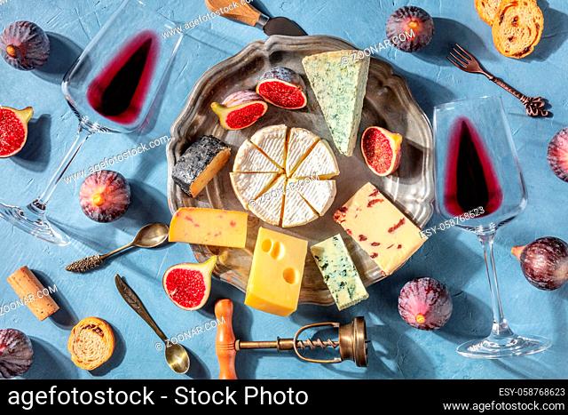 Cheese and wine, shot from above. Camembert, blue cheese and other cheeses with red wine, a romantic French dinner